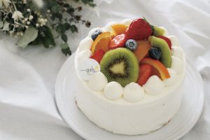 フルーツがたくさん載った生クリームのホールケーキ