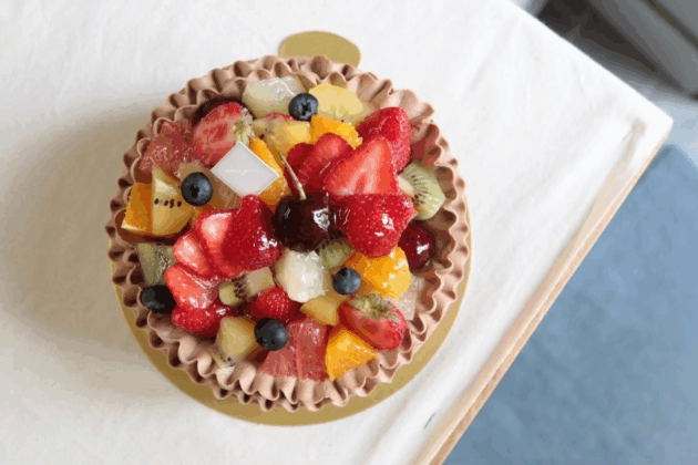 いろいろな種類のフルーツをたくさん載せたチョコ生クリームケーキ